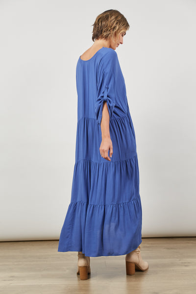 side view of Euphoria Azure Blue button V-neck tiered maxi dress with long sleeves rolled up in a tab from Isle of Mine