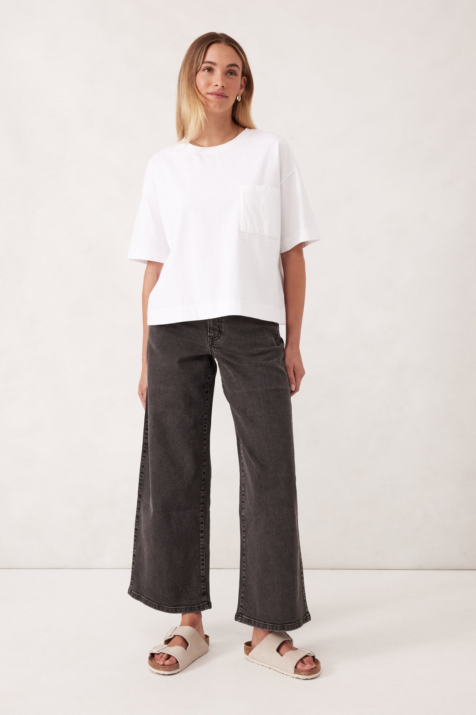 Model wearing the Boa Boxy T-shirt in White with crew neck, short sleeves and a pocket by Ceres Life.