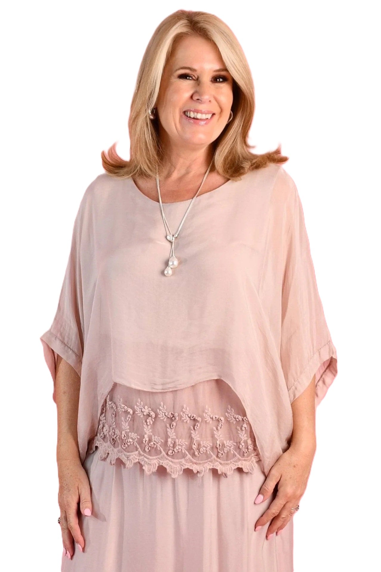 Woman wearing the Marta light blush pink silk blend top with lace inset, floaty sleeves and a round neckline by La Sofia.