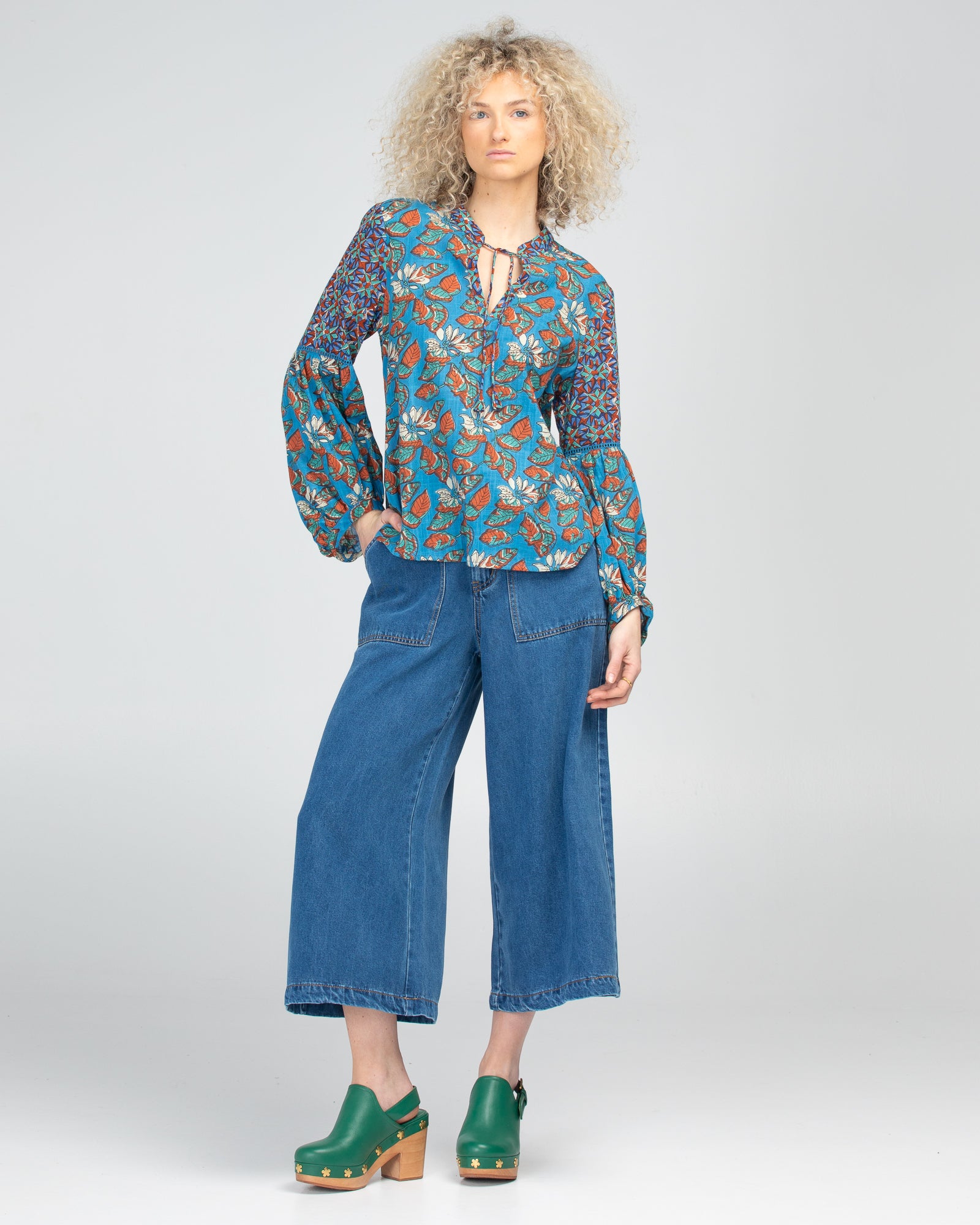 Mittee Top with a V-Neck with tie and grandpa collar, long sleeves with contrasting print and slight puff from the elbow and a curved hem.