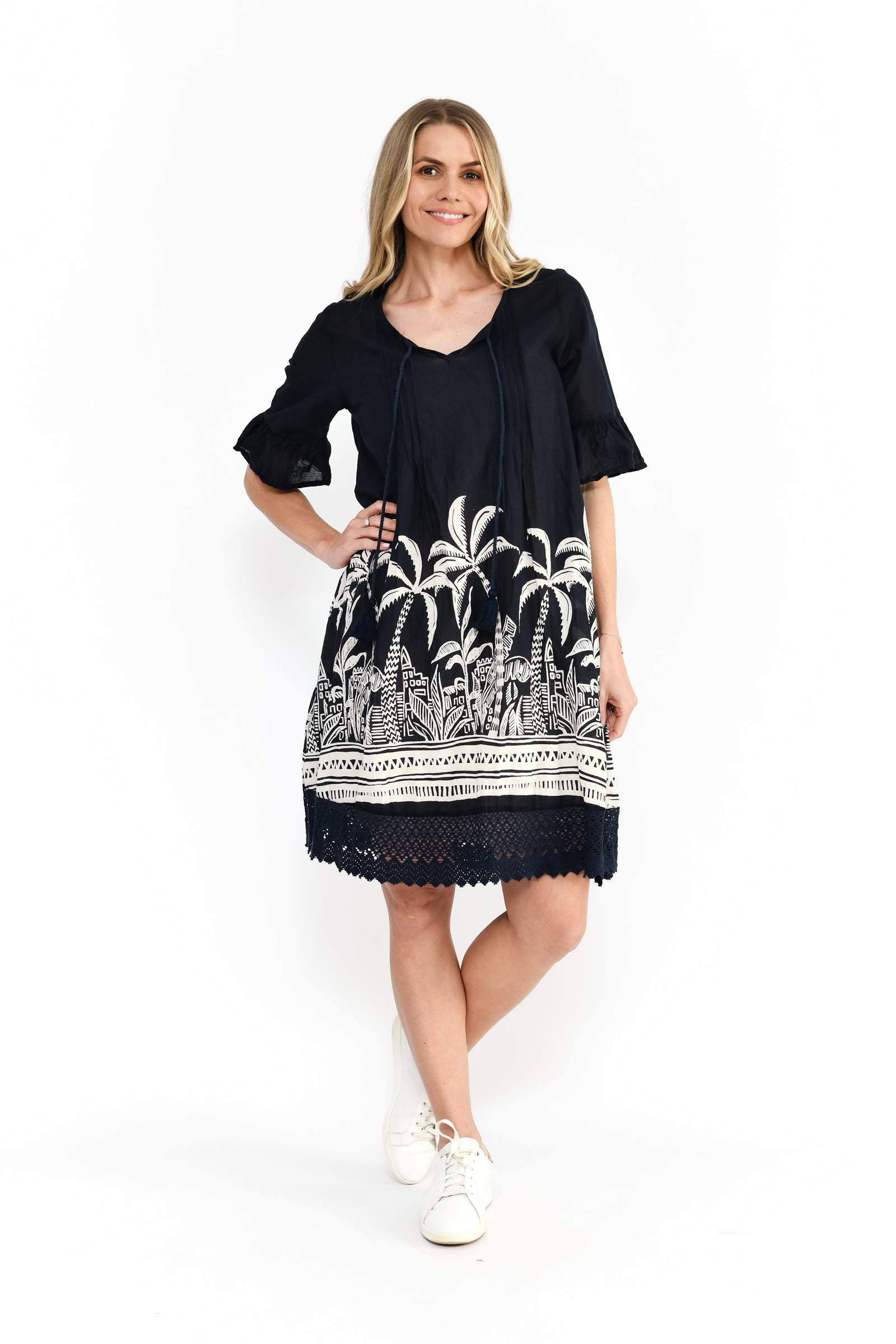 Woman wearing black and white palm print Cotton Hannah Tunic Midi Dress with a v-neck and short sleeves with embroidered hem by One Summer.