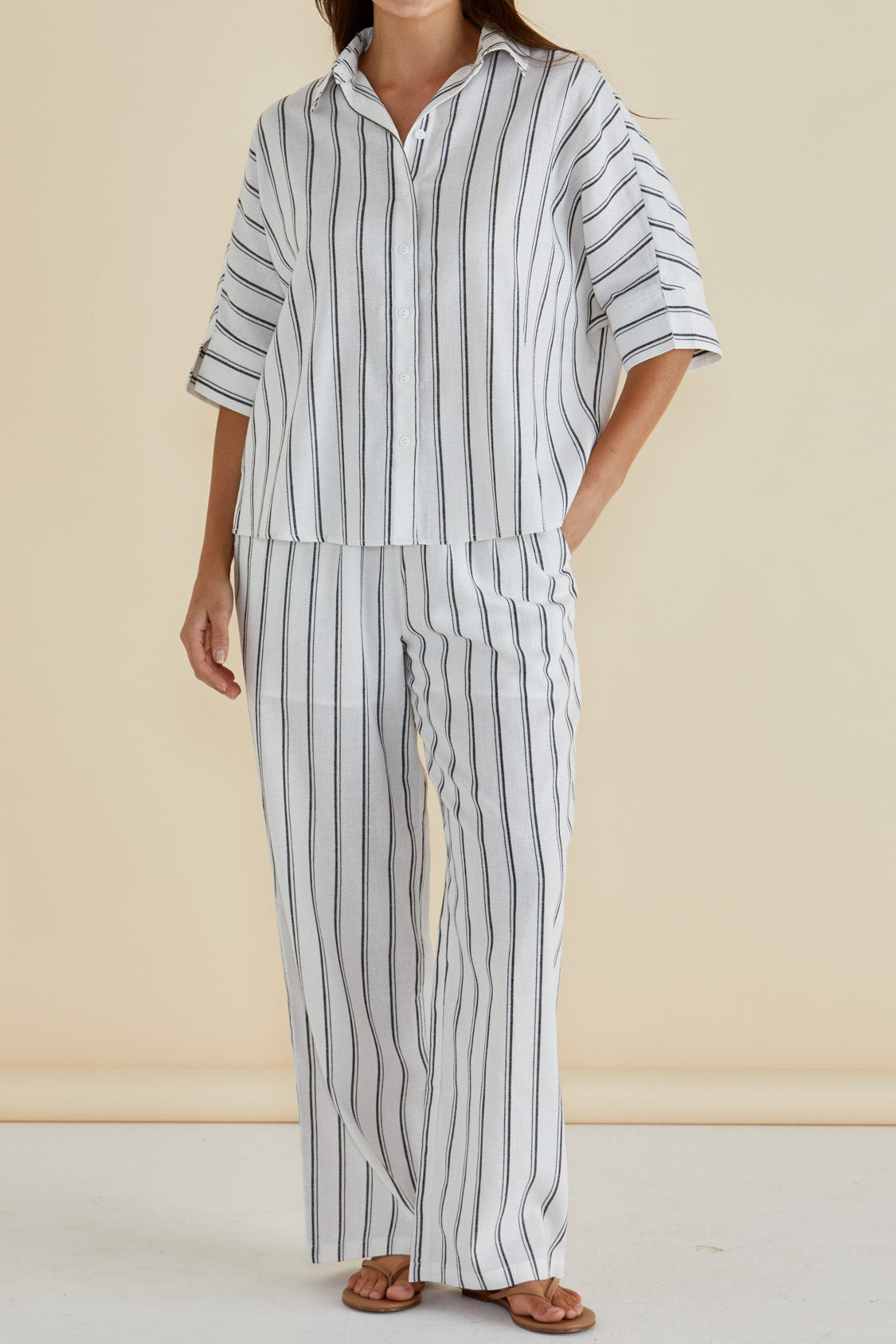 Woman wearing Zaza relaxed pants in white and black stripe, full length and mixed blend including linen and cotton f rom Betty Basics.
