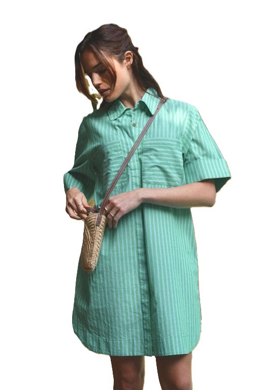 Woman wearing the Sara Mini Shirt Dress in Green and White stripe with double front pockets, collar and button up front, short sleeves with roll cuffs by Ceres Life.