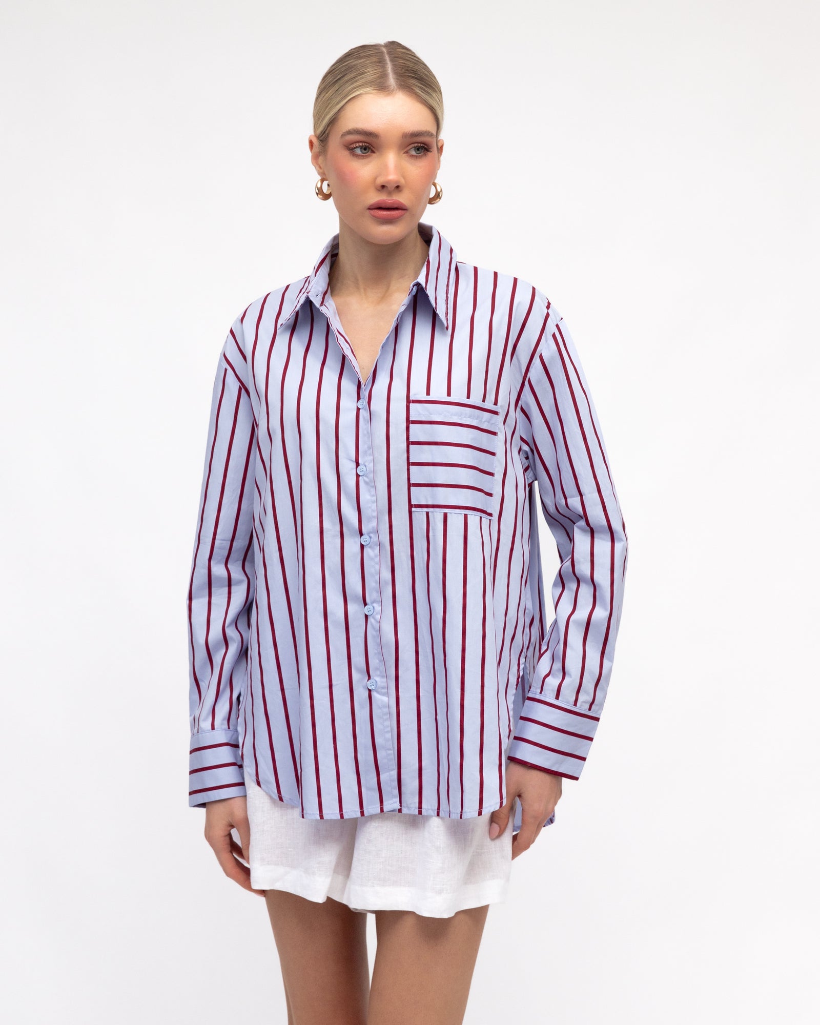 Woman wearing caddy striped long sleeve shirt in pale blue and red by White Closet.