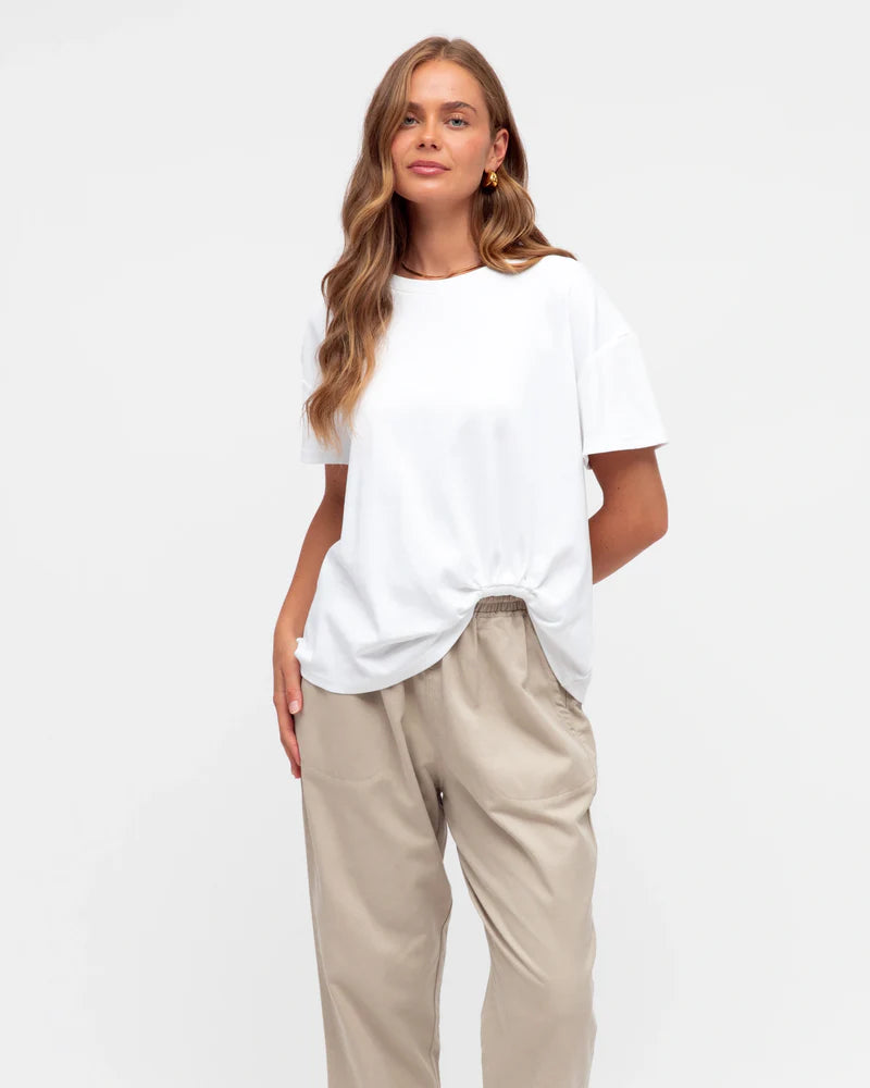 Woman wearing the white Tuck t-shirt with short sleeves, round neck, straight hem by Label of Love.