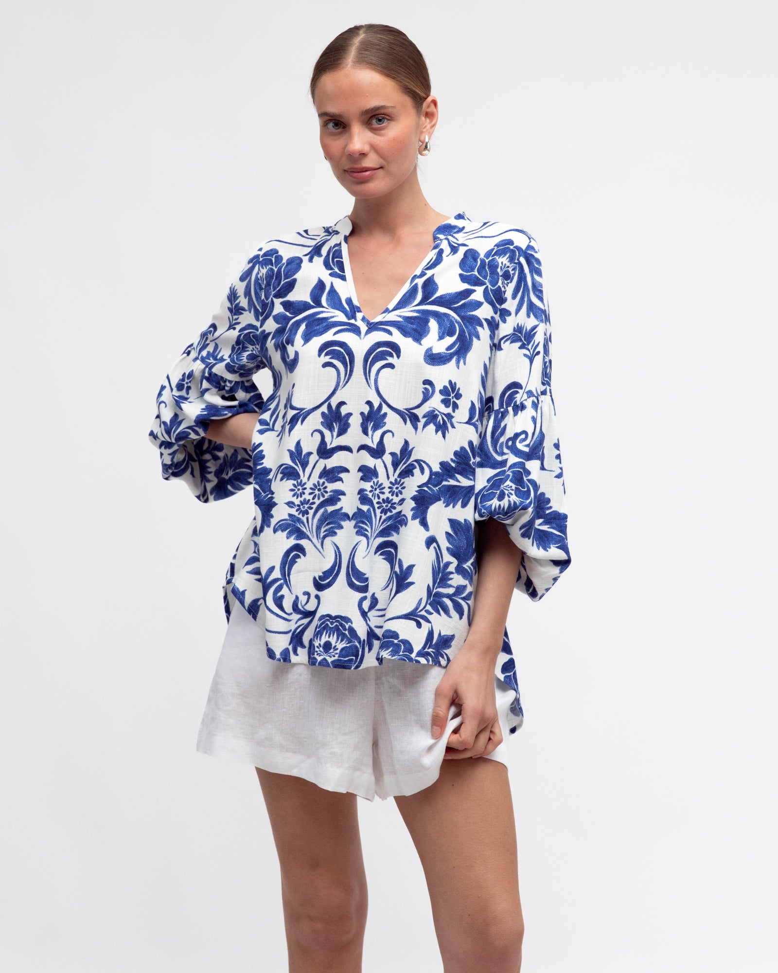 Woman wearing a blue and white floral blouse.