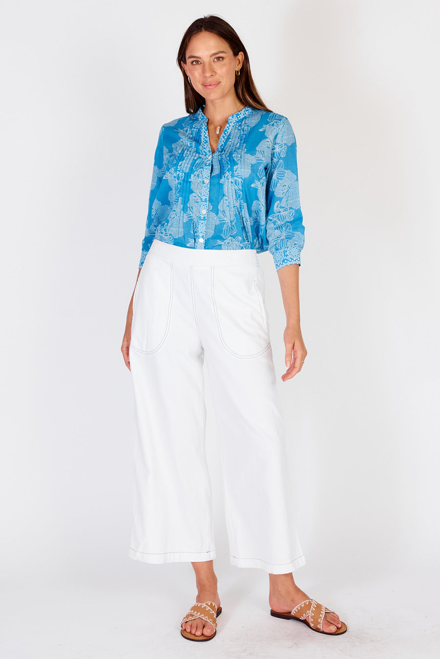 Woman wearing white cotton Pula pants from Rubyyaya with a slight crop above ankles.