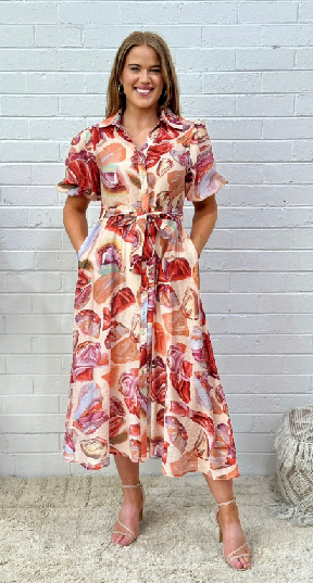 Woman wearing the red and orange gem print shirt dress by Sambara.