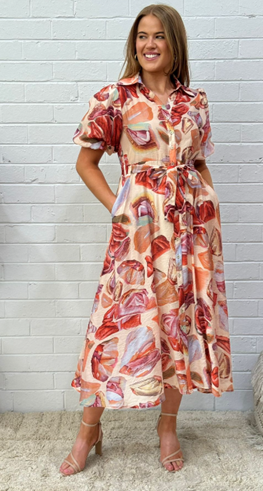 Woman wearing the red and orange gem print shirt dress by Sambara.