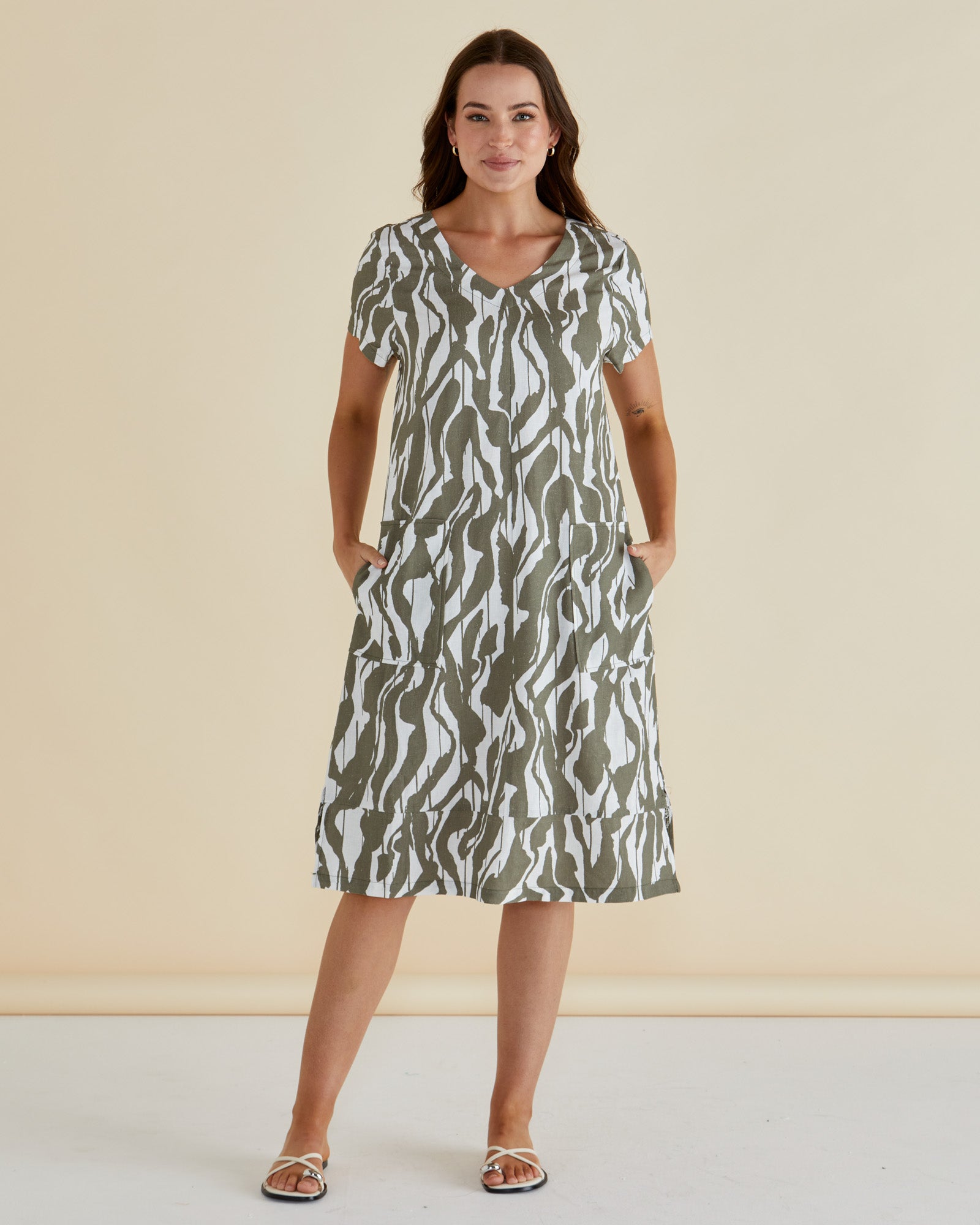 Woman wearing Betty Basics Elwood tshirt midi dress in olive green and white geometric print with vneck and short sleeves.