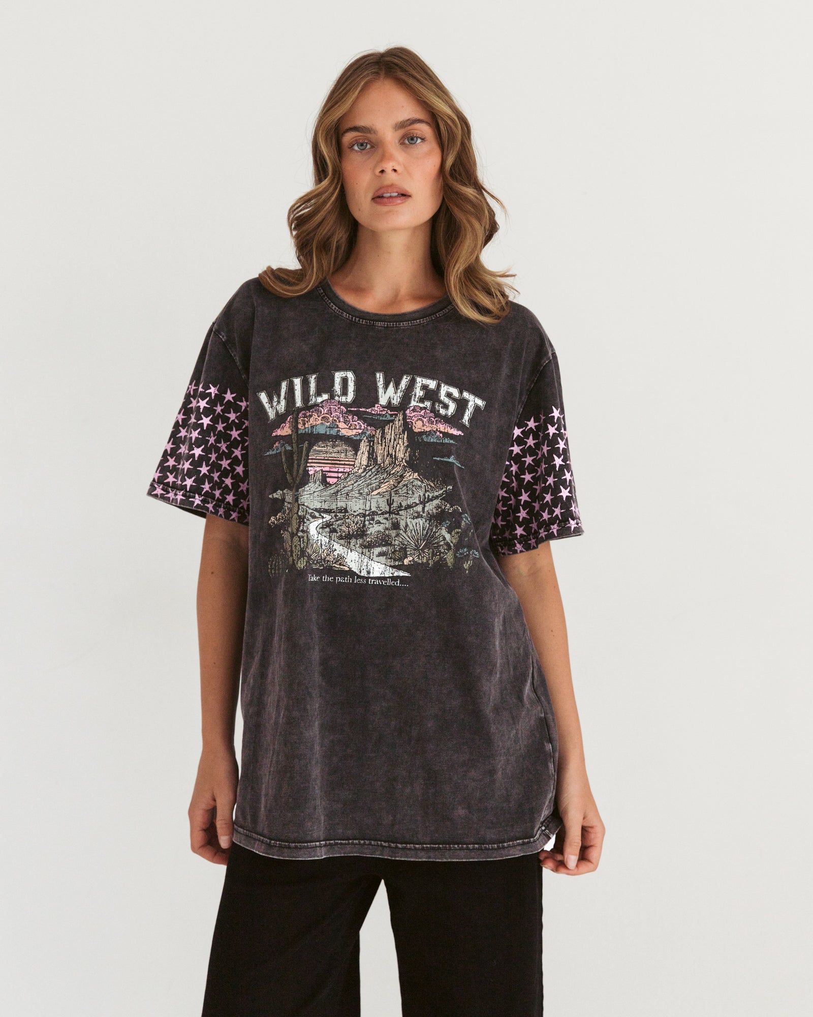 Woman wearing vintage black tshirt with wild west desert picture on the front, and pink stars on the short sleeves by Paper Heart.