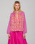 Model wearing a patterned cotton Fleetwood Top in Spliced Naples a pink, white and red print with long sleeves a v-neck and straight hem.