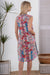 model wearing Cienna's Cinta Floral Midi Dress in a sleeveless shirt dress style in blue, red white and pink.