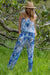 Woman in a blue and white floral sleeveless jump suit with an elasticated top and waist by Cienna 