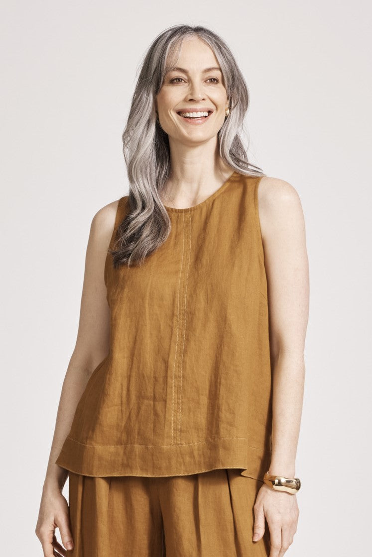 Woman wearing sleeveless caramel brown tank top with contrast stitching by eb&ive.