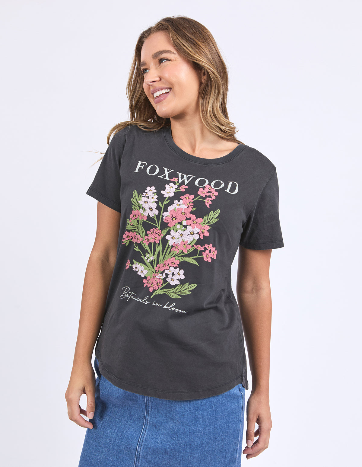 Woman wearing a washed black Flowers Tee with short sleeves, round neck, curved hem T-shirt from Foxwood.