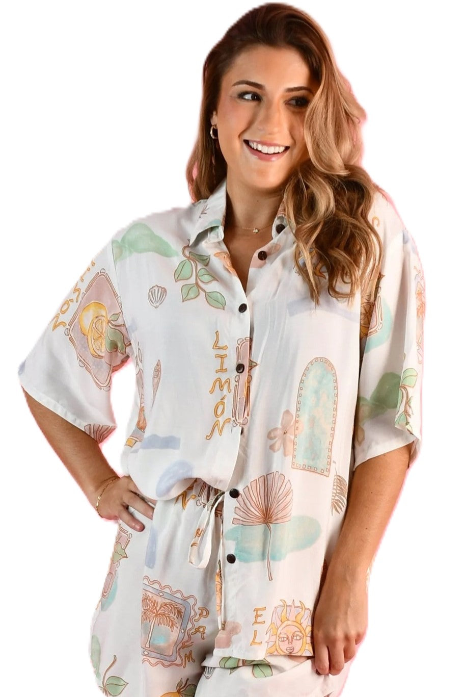 Woman wearing the yacht Shirt in Zesty Postcard lemon print a white, green, blue and yellow print with short sleeves, classic collar and button up front.