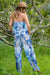Woman in a blue and white floral sleeveless jump suit with an elasticated top and waist by Cienna 
