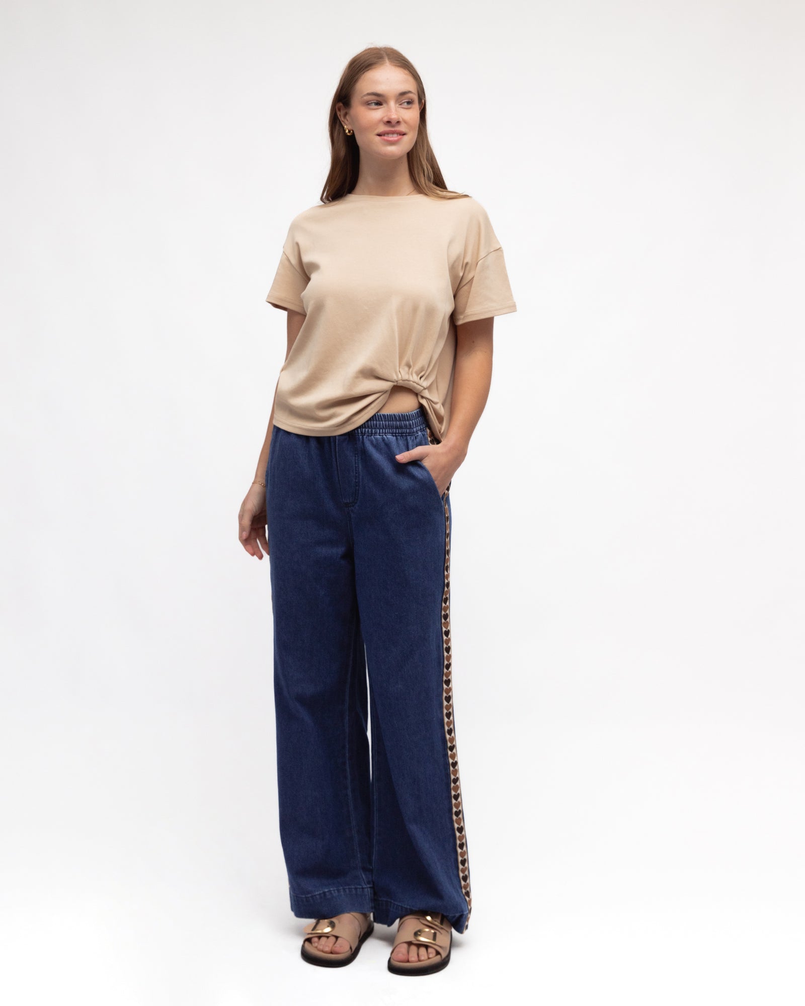 Woman wearing Label of Loves Side Stripe jeans with Love Hearts, pockets, elasticated waist and full length in a mid denim blue.