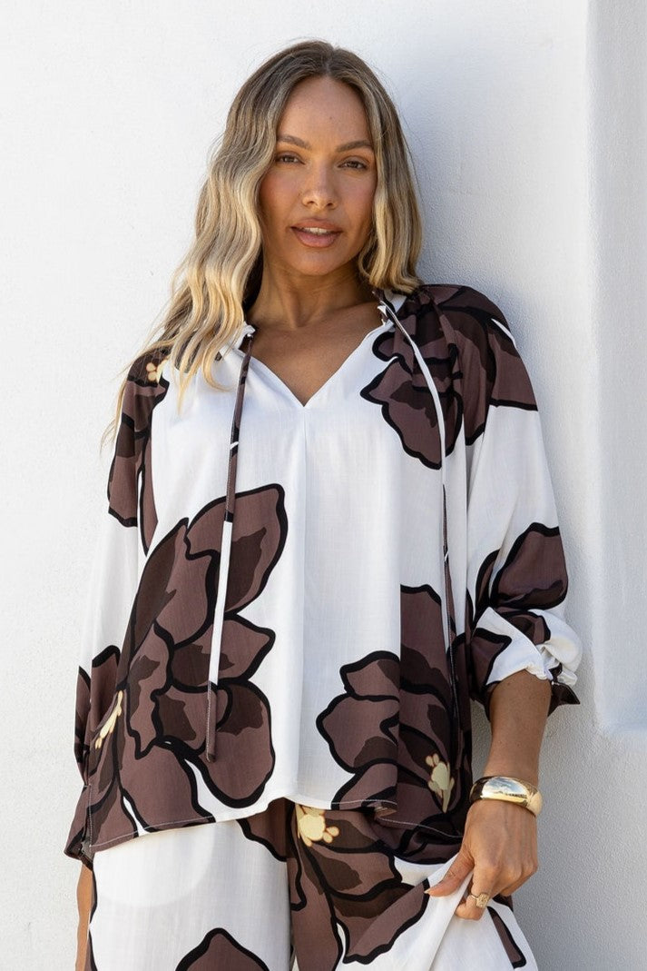Woman wearing a Shona white blouse with brown Smoky Chocolate floral print  by Jatea.