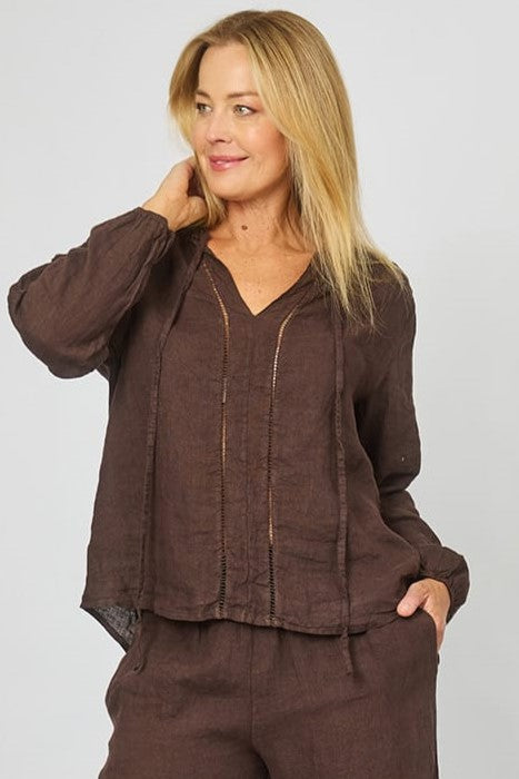 Woman wearing Long Sleeve Linen Top in Chocolate wtih eyelet broderie embroidery down the front, v-neck and ties by La Strada.