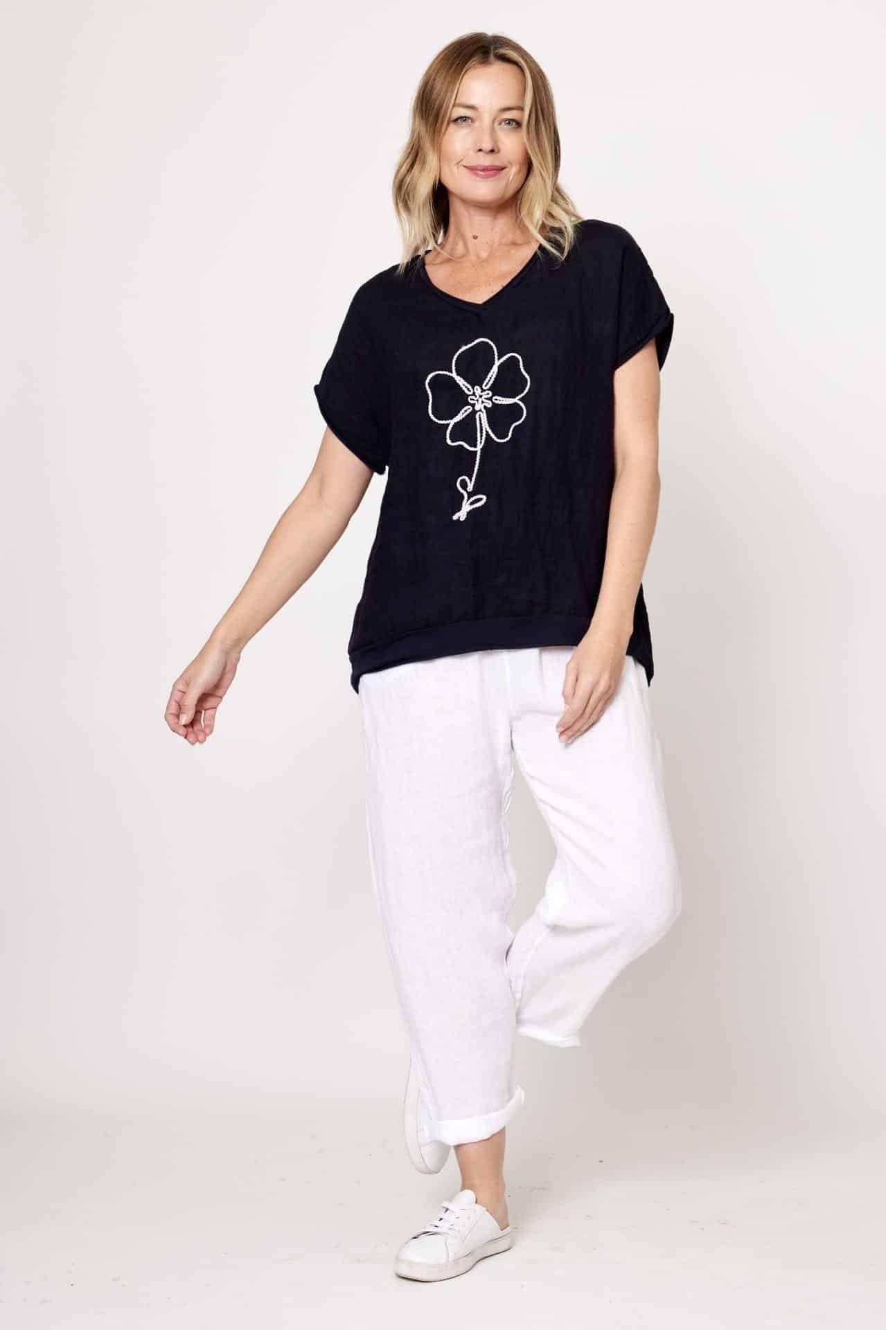 Model wearing La Strada's Navy Linen Tee with a white flower embroidered on the front. 