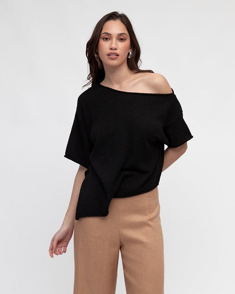 Woman wearing the Asy Knit Off Shoulder Black Top by White Closet with a pointed hemline and short sleeves.