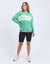 Woman wearing a green cotton tonal crew sweatshirt with 'FOXWOOD' logo on front.