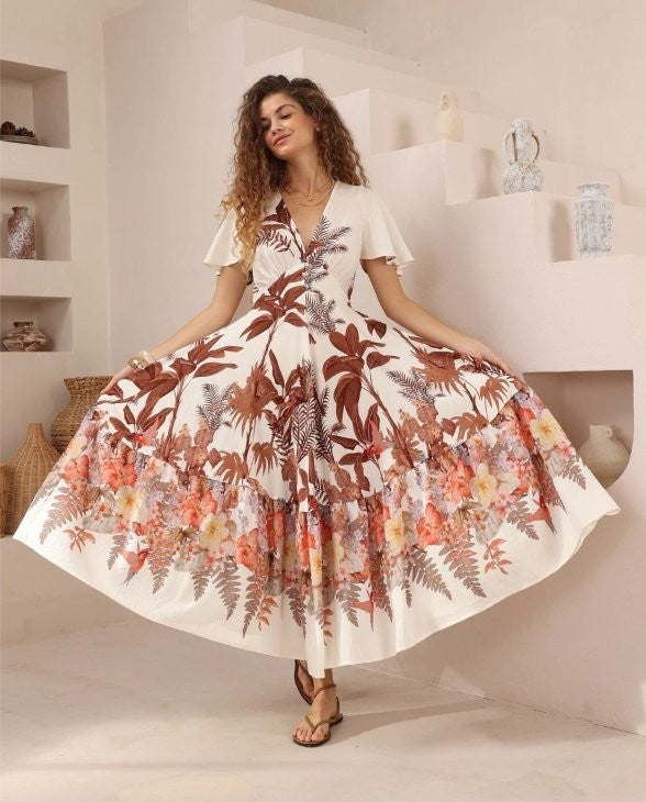 Woman weraing the iris maxi tropical botanical print dress with v-neck short sleeves and full skirt.
