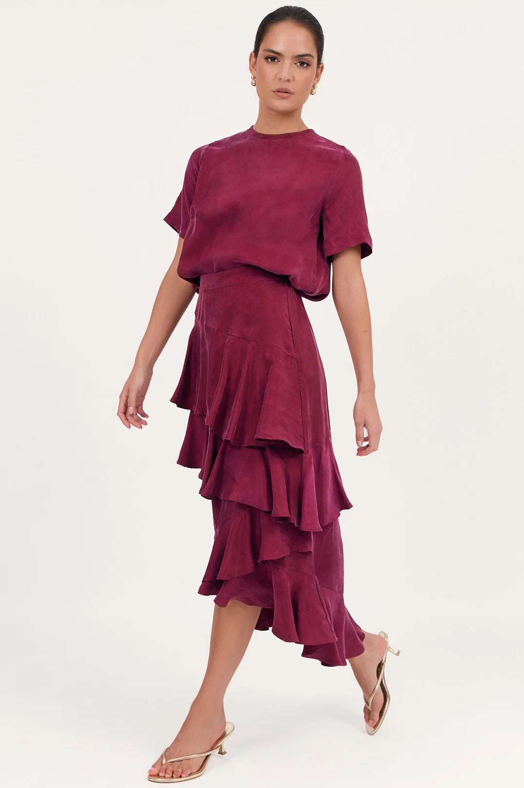 Side view of the Peta burgundy cupro frill skirt with a high low hem by Adorne.