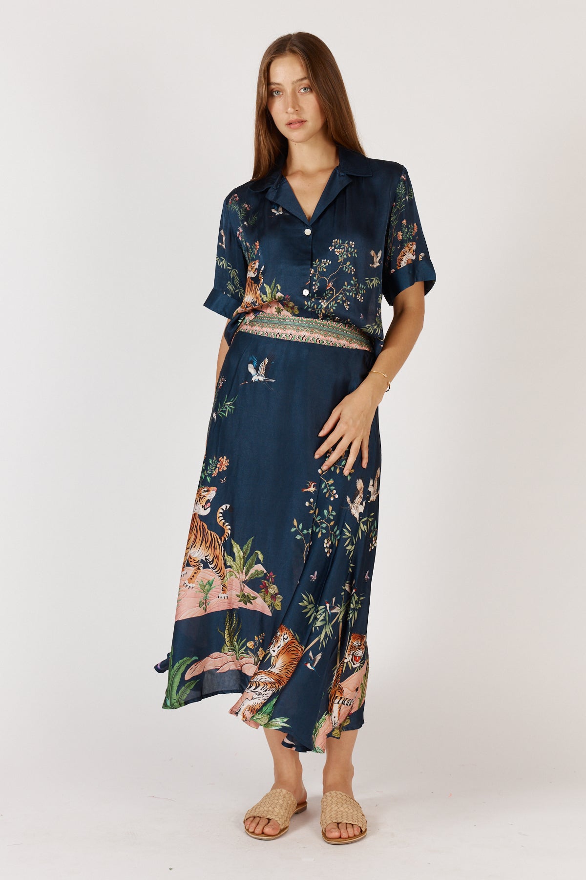Woman wearing blue satin midi skirt with tigers and jungle print by Rubyyaya.