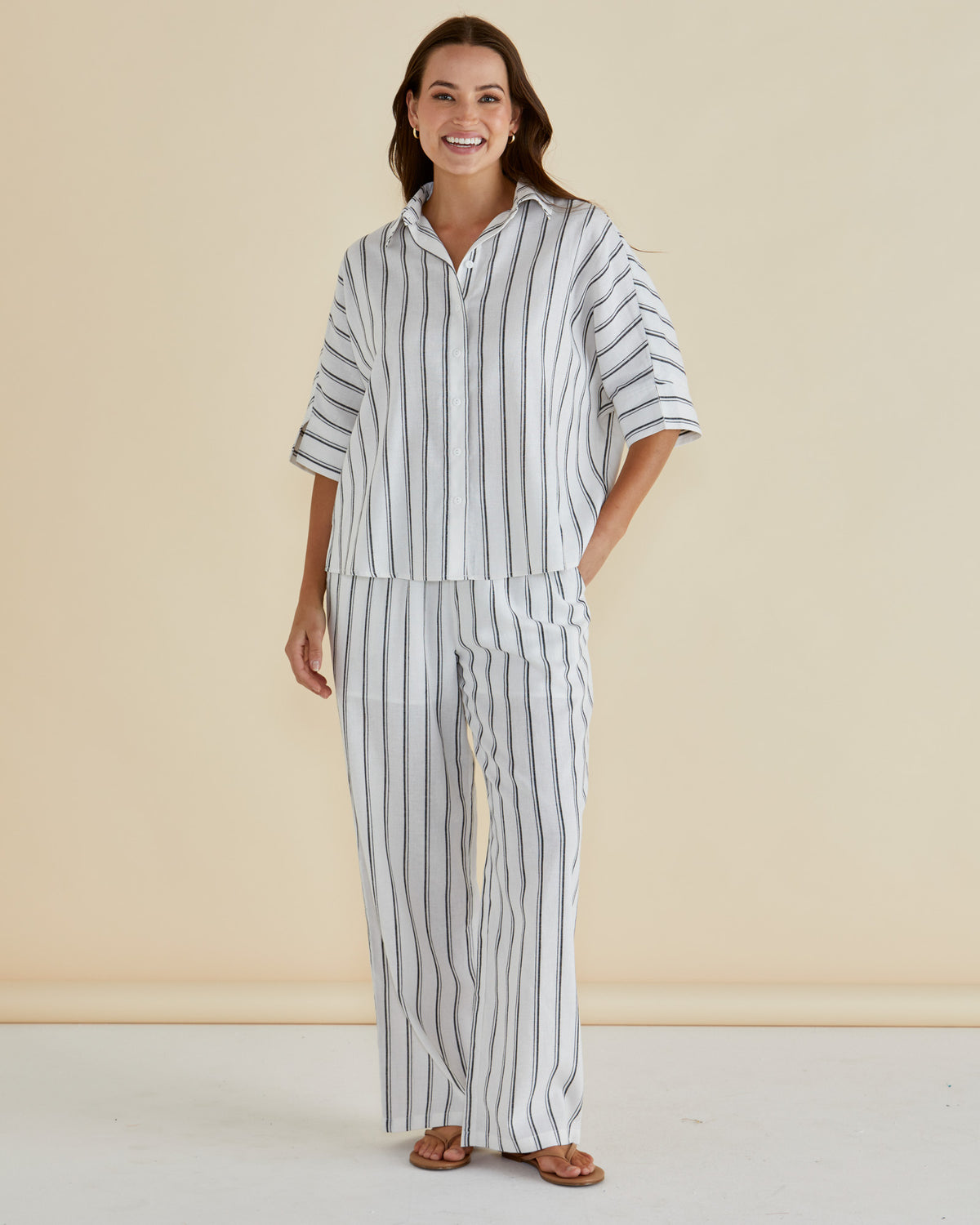 Woman wearing  Zaza relaxed pants in white and black stripe, full length and mixed blend including linen and cotton f rom Betty Basics.