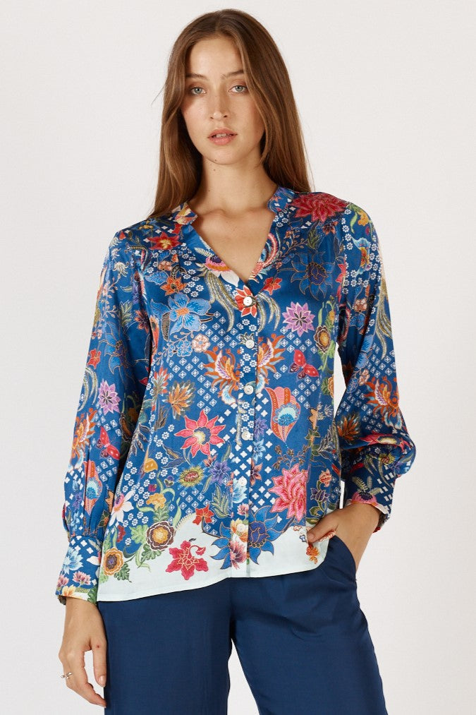 Woman wearing a colorful floral Toscana long Sleeve Shirt with long sleeves and grandpa collar by Rubyyaya.
