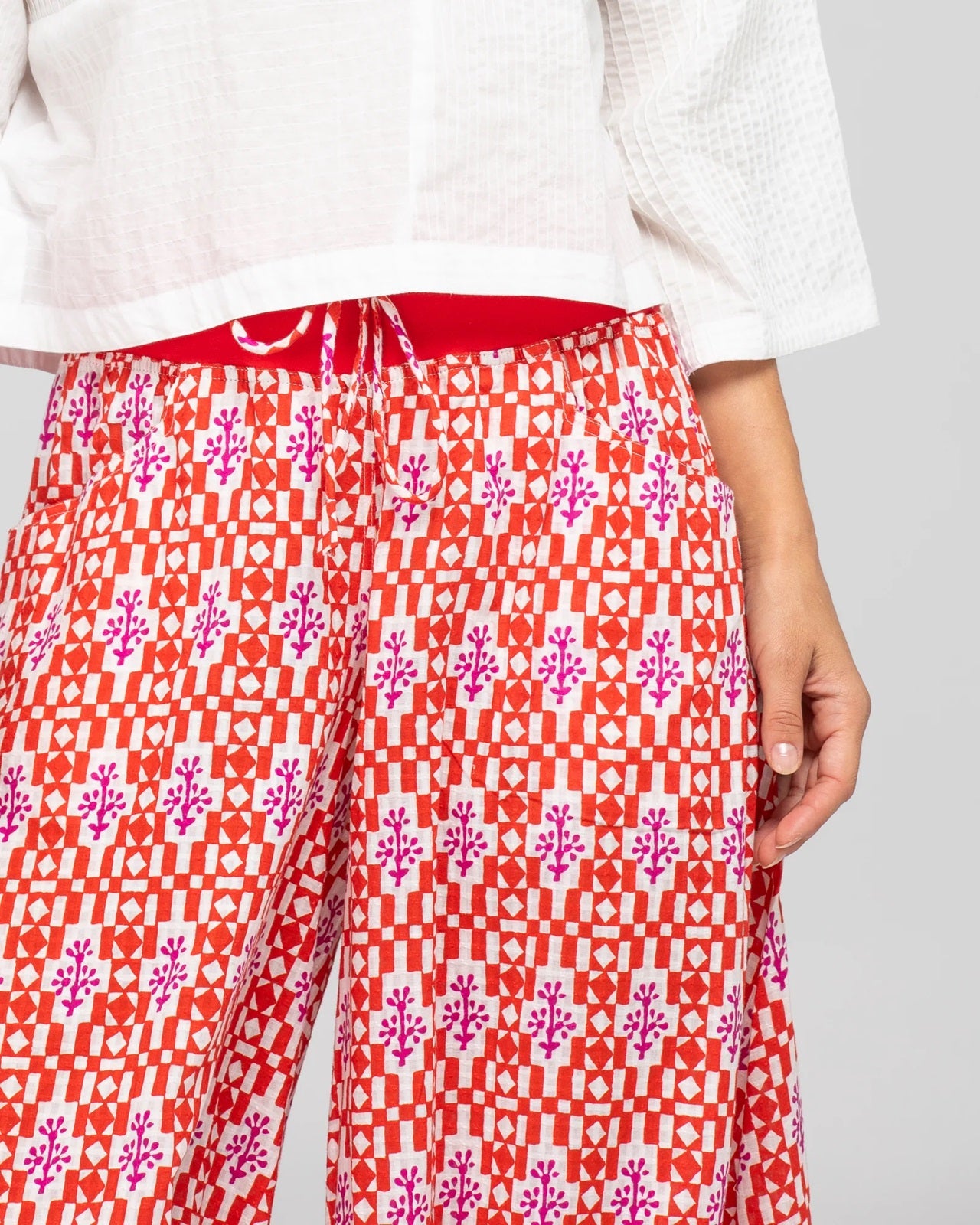 Lady wearing Boom Shankar's Cotton Cropped Guru Pants in Naples Pomodoro a fun red, white and pink print crop pant.