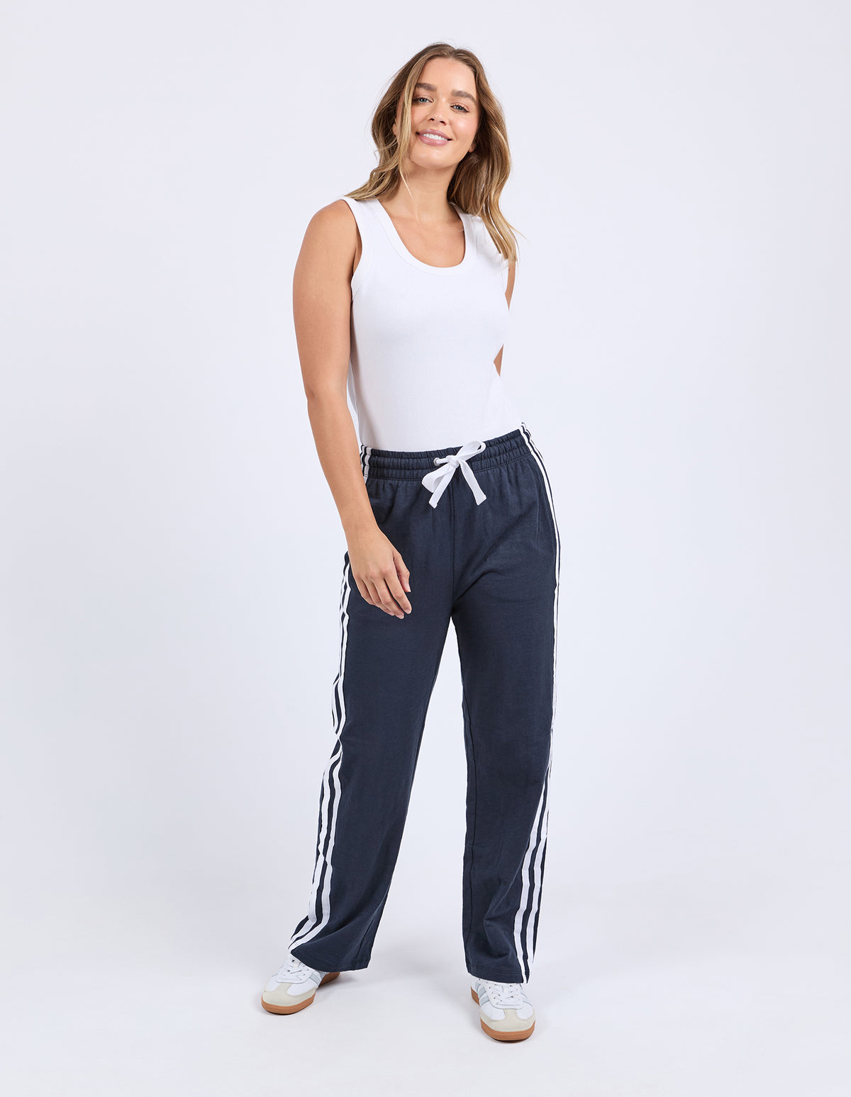 Lady wearing Foxwood's navy blue Power Pants / jogger bottoms with White side stripes, 100% lightweight Cotton with a full length.