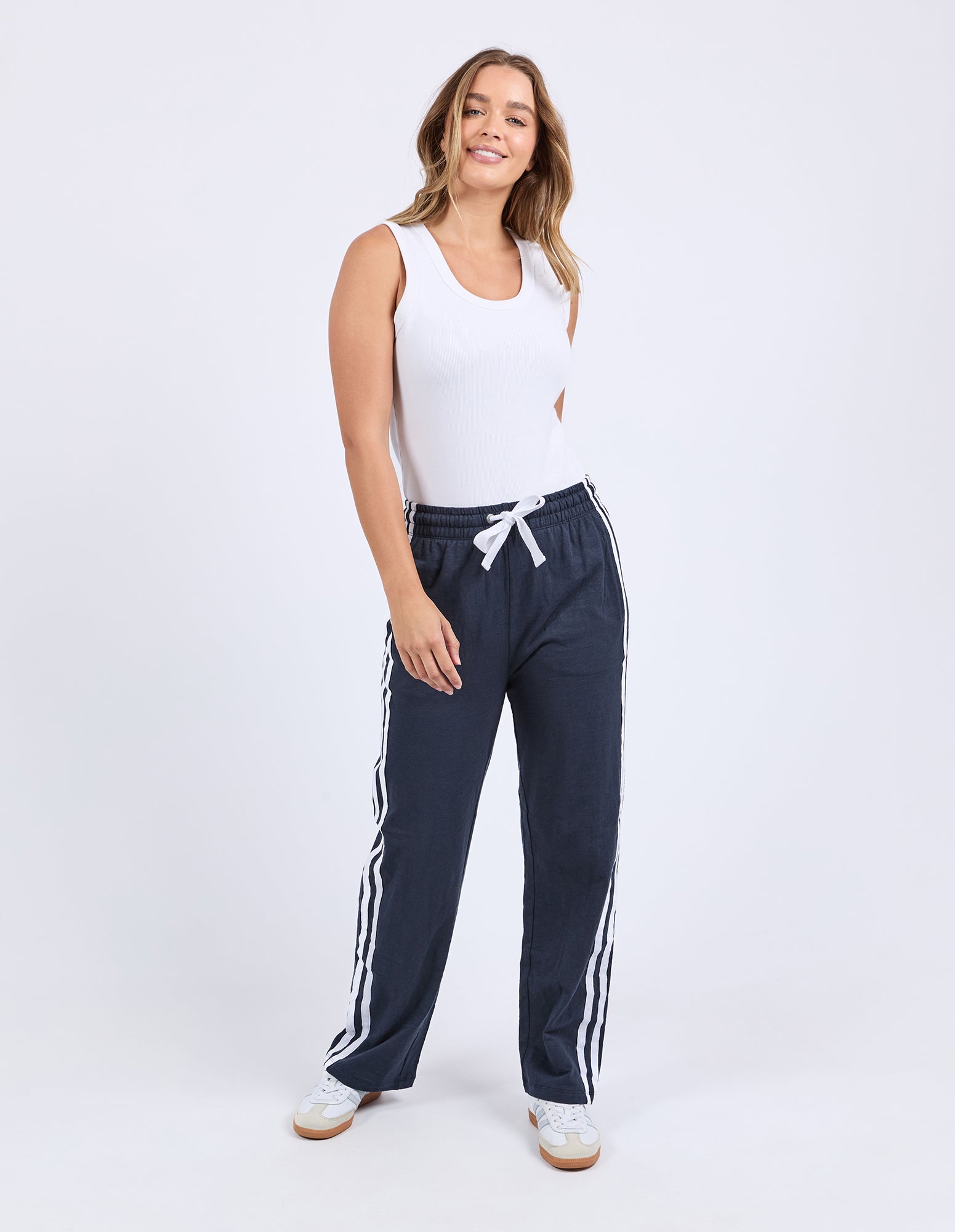 Lady wearing Foxwood's red Power Pants / jogger bottoms with White side stripes, 100% lightweight Cotton with a full length.