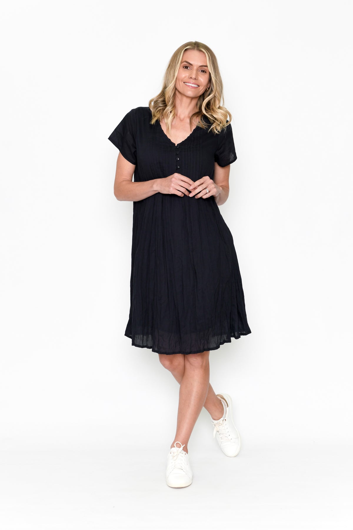 Woman wearing One Summer's Black Taylor cotton Midi Dress with cap sleeves, pockets, lining and tuck detailing.