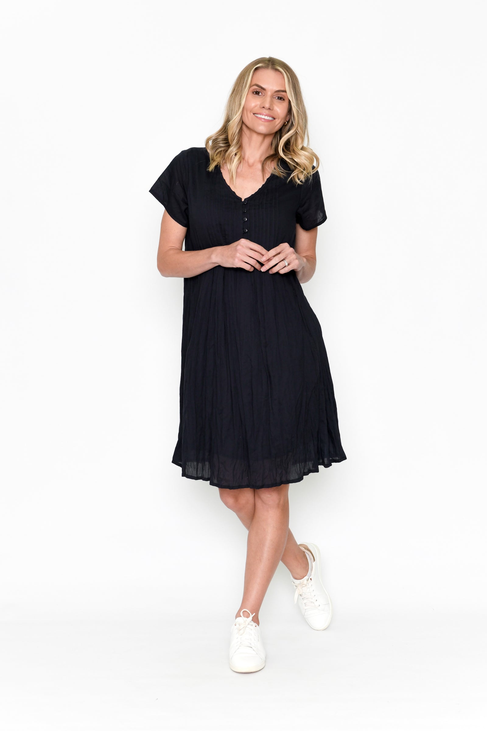 Woman wearing One Summer's Black Taylor cotton Midi Dress with cap sleeves, pockets, lining and tuck detailing.