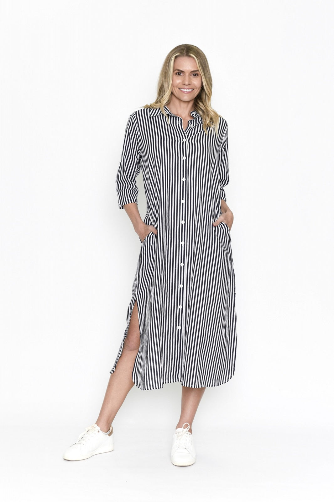 Woman wearing navy blue and white striped midi shirt dress with collar and button up front, pockets and side splits this casual dress is from One Summer.