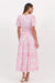 Back of Eliana Port Villa Maxi Dress in pink and white palm tree print with short sleeves V-Neck, shirred waist and tiered skirt by Adorne.