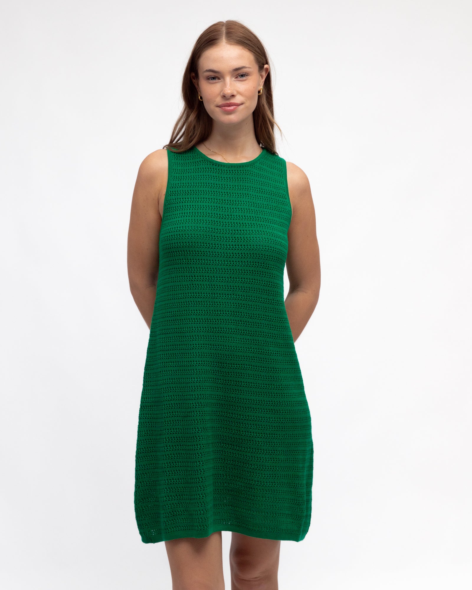 Woman wearing an emerald green knit sleeveless midi / mini dress by Paper Heart.