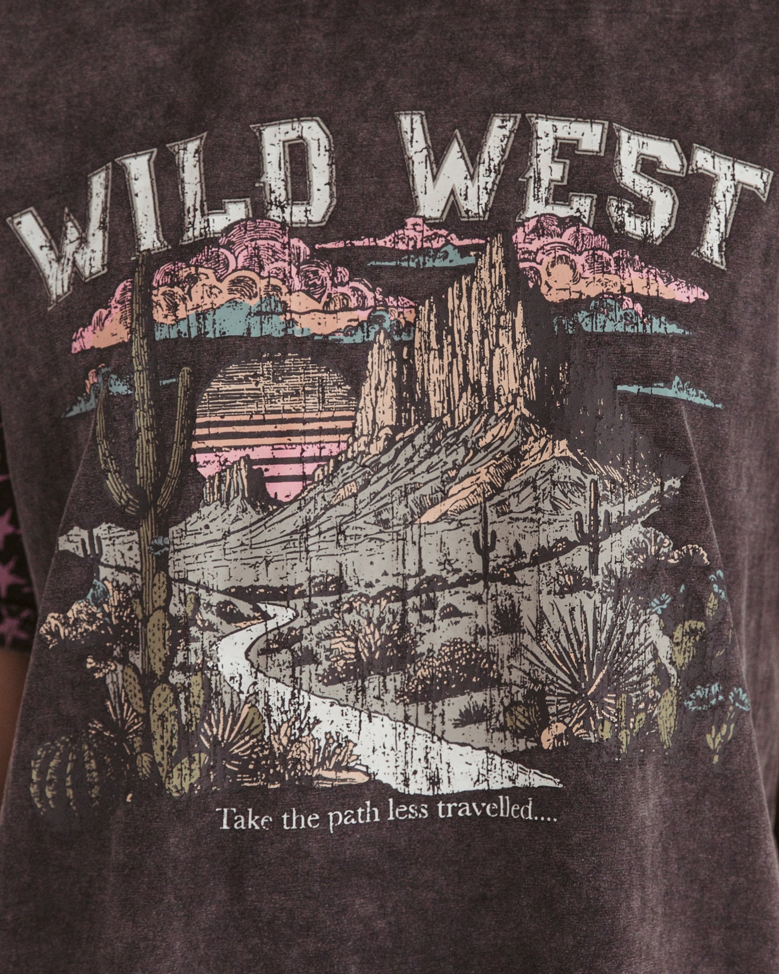 Woman wearing vintage black tshirt with wild west desert picture on the front, and pink stars on the short sleeves by Paper Heart.