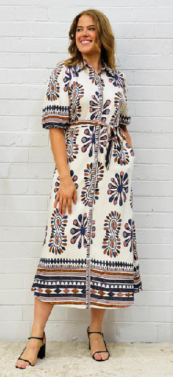 Woman wearing below knee shirt dress in blue and white floral dress by Sambara.