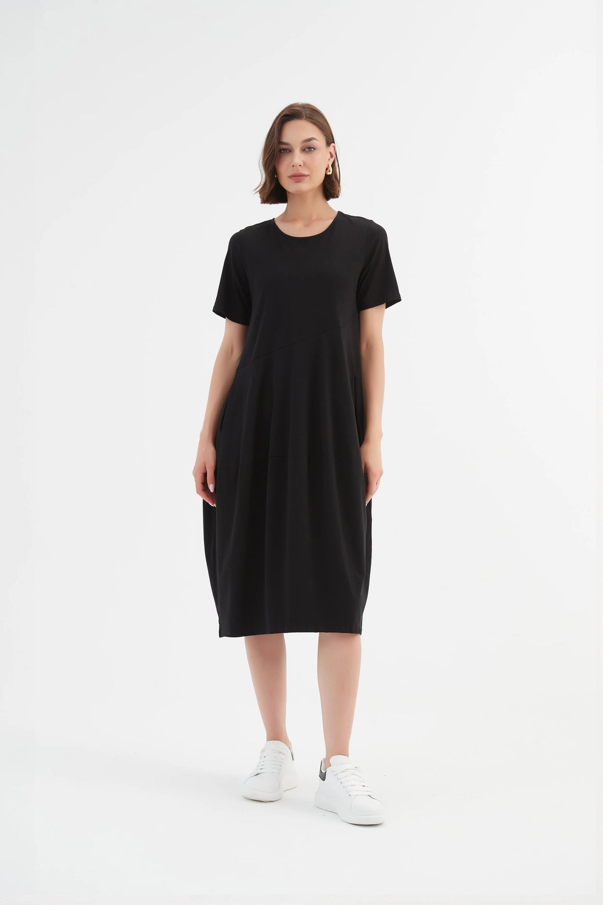 Model wearing Tirelli's black short sleeve diagonal sleeve midi dress.