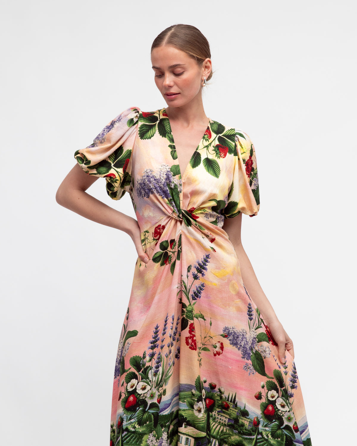 woman wearing pink floral and building print twist front dress from white closet.