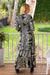 Lady wearing Cienna's Silk blend Myra Bohemian maxi dress with a v-neck, shirred under bust, long sleeves and a tiered skirt with ruffles in a goregous black, green, blue and honey toned floral paisley print.