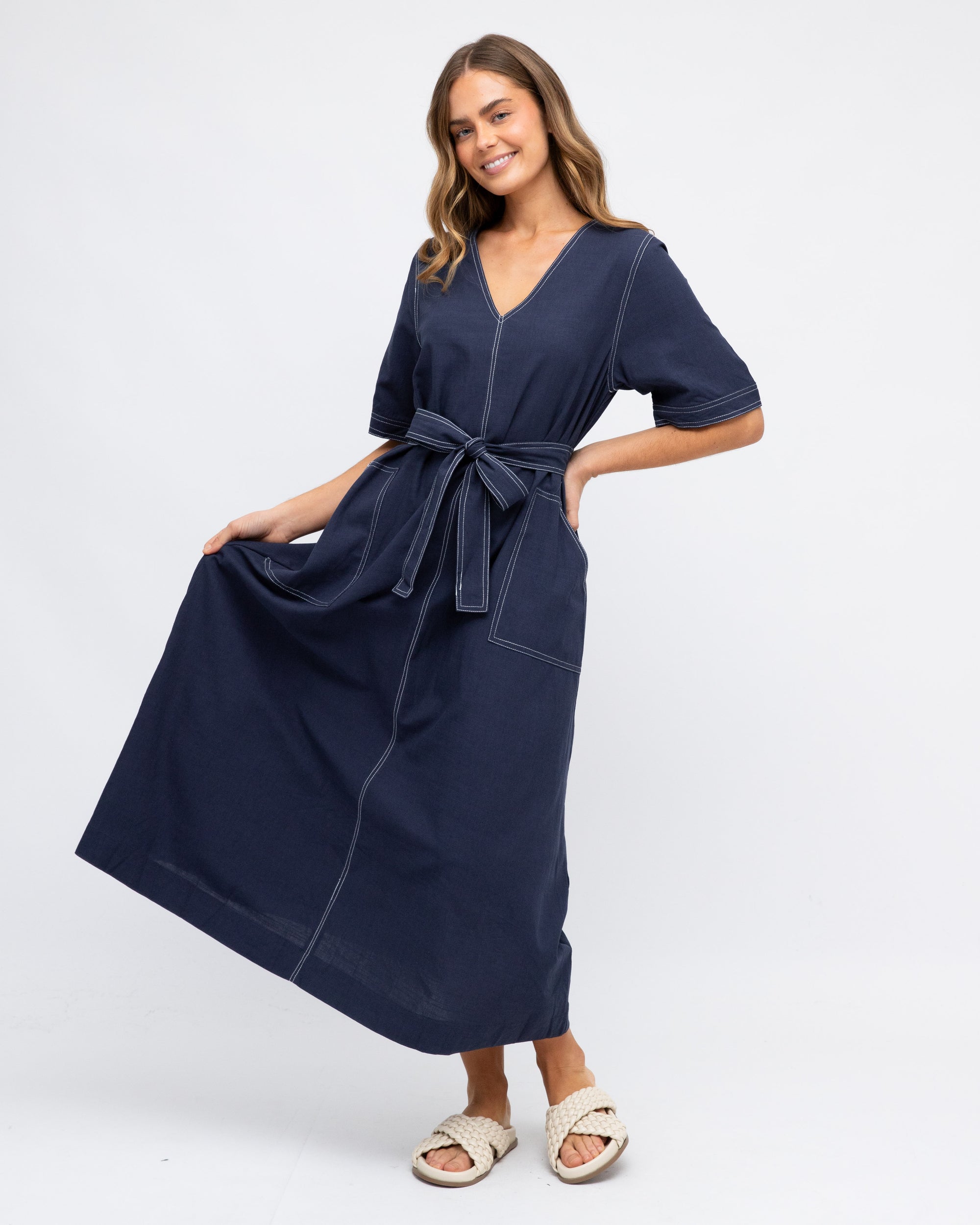 Lady wearing navy Blue contrast stitch maxi dress with front pockets, removable fabric tie waist and elbow length sleeves by label of Love.