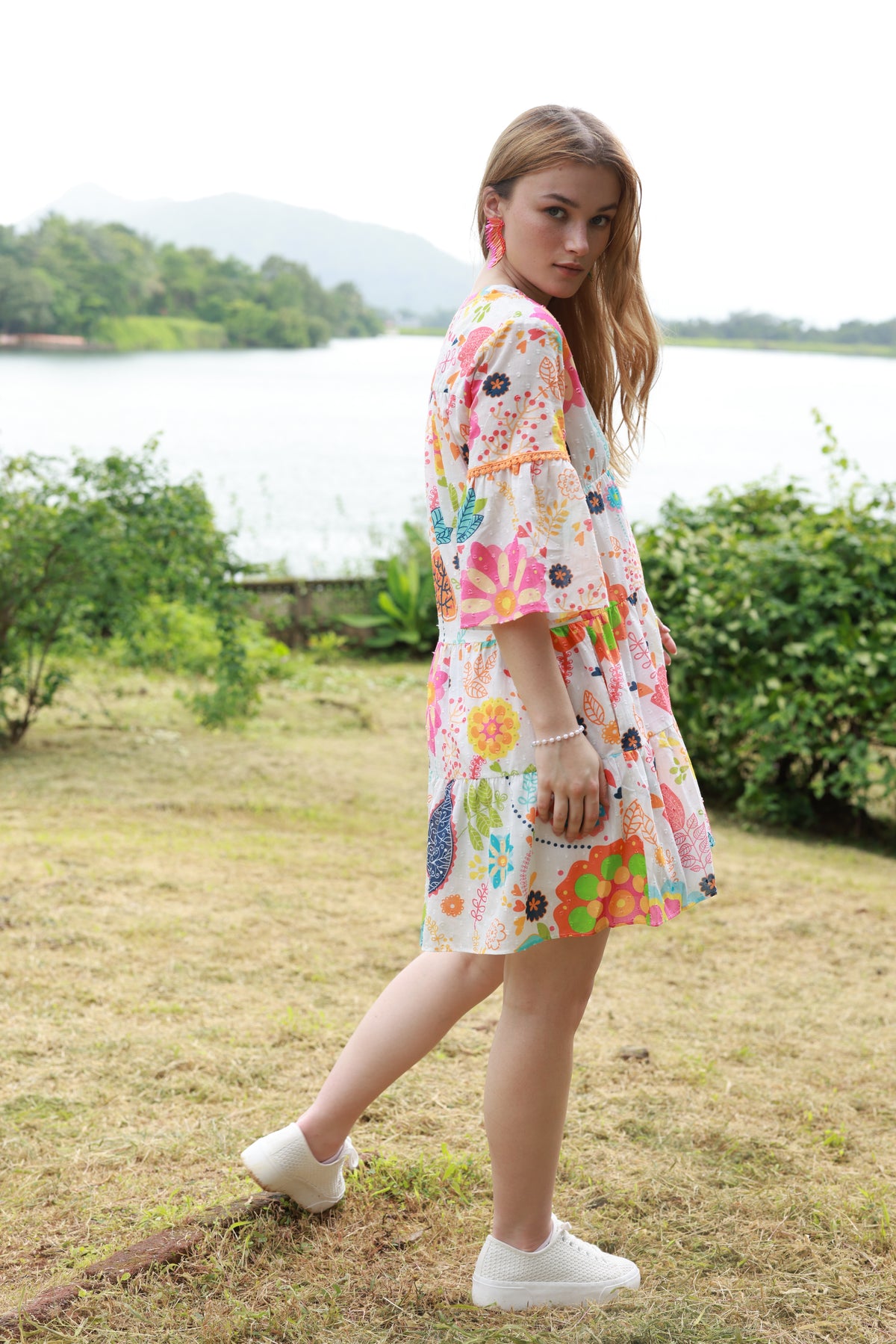 Side View of the white wendy dress with orange pink green blue summer garden print. 