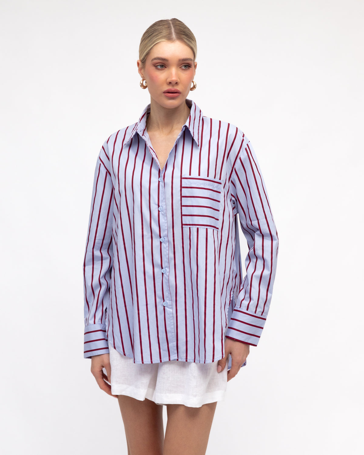 Woman wearing caddy striped long sleeve shirt in pale blue and red by White Closet.