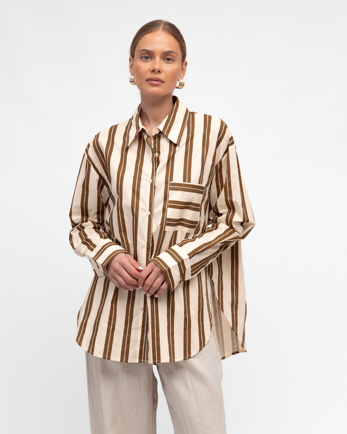 Woman wearing White Closet&#39;s long sleeve Francine Stripe Shirt in Cream and Brown.